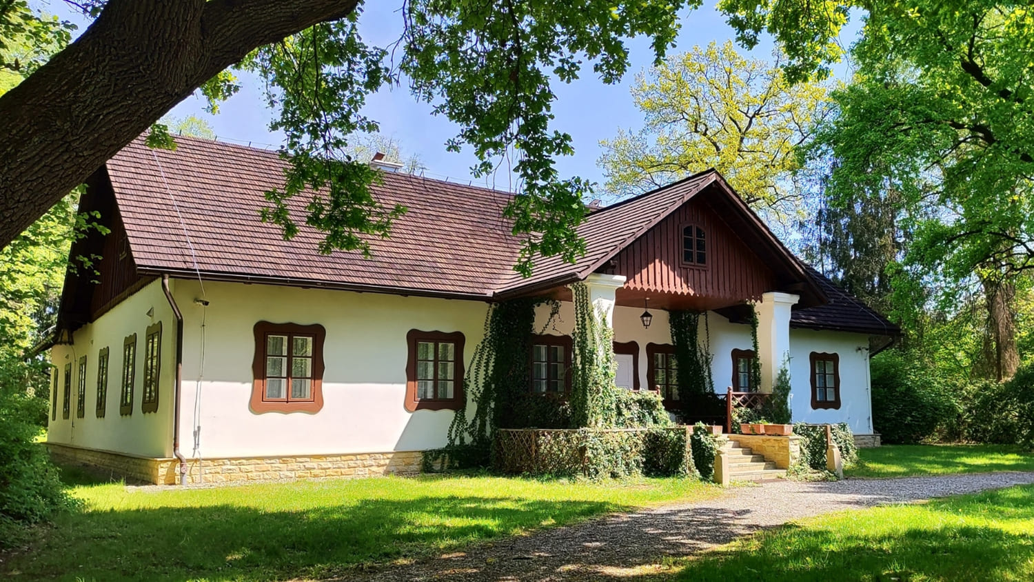 Dworek otoczony drzewami Muzeum w Dołędze