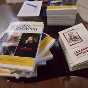 Na stoliku ułożone w małe stosy dwie książki. po lewej rocznik tarnowski. po prawej Jan Amor Tarnowski.