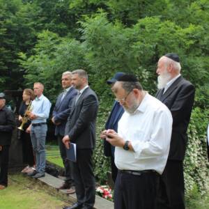 Mężczyźni stojący w rzędzie. na pierwszym planie dwóch rabinów.