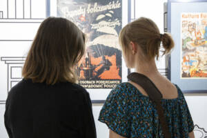 dwie kobiety przy starym plakacie