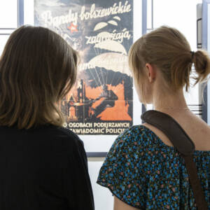 dwie kobiety przy starym plakacie